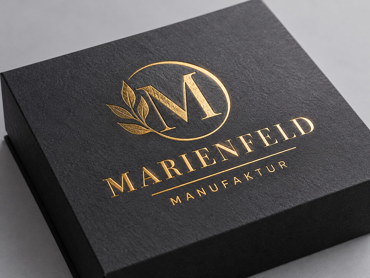 Goldene Heißfolienprägung mit dekorativem Logo auf schwarzer hochwertiger Verpackung